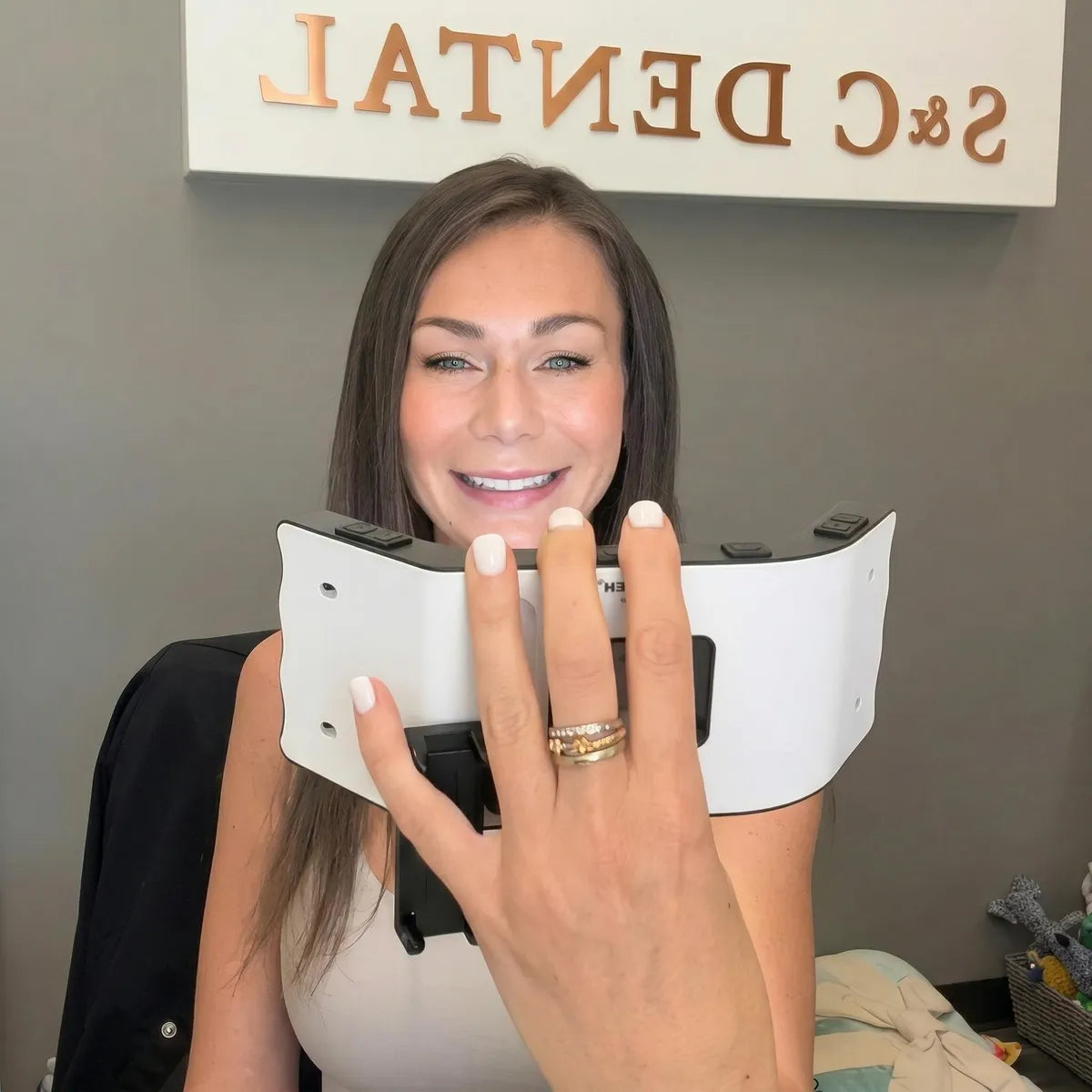 Dentist holding the dental photography light in her clinic.