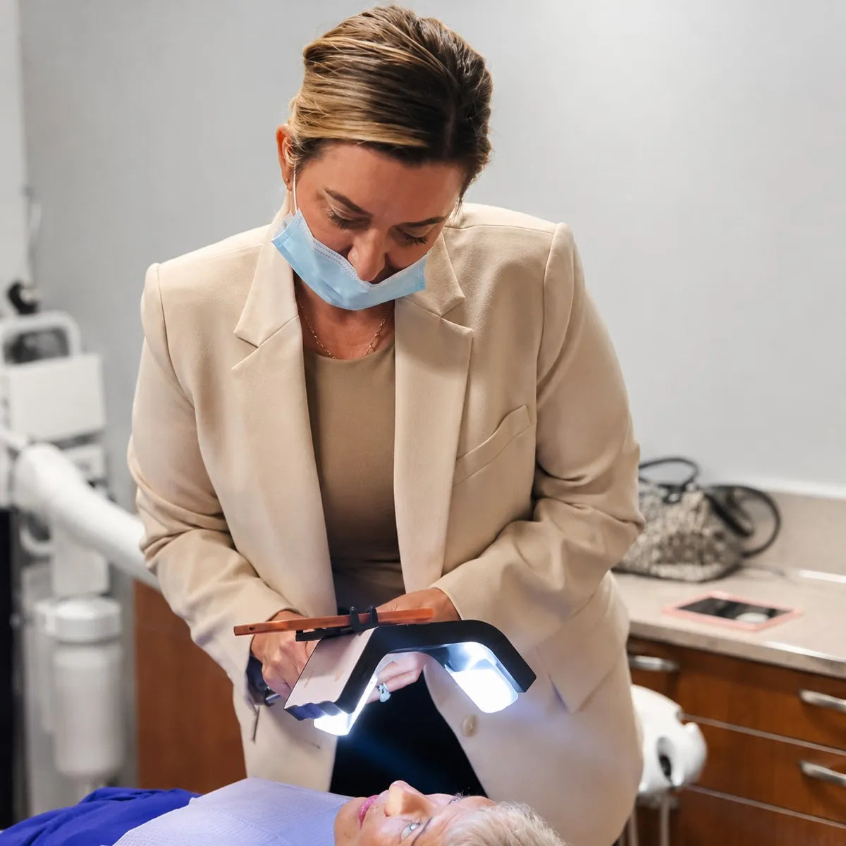 Dentist using a dental photography light on a patient.