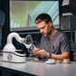 Dental technician at lab workbench with dust collector and dental models