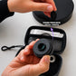 Dental macro lens 100mm held in hand with carrying case and accessories.