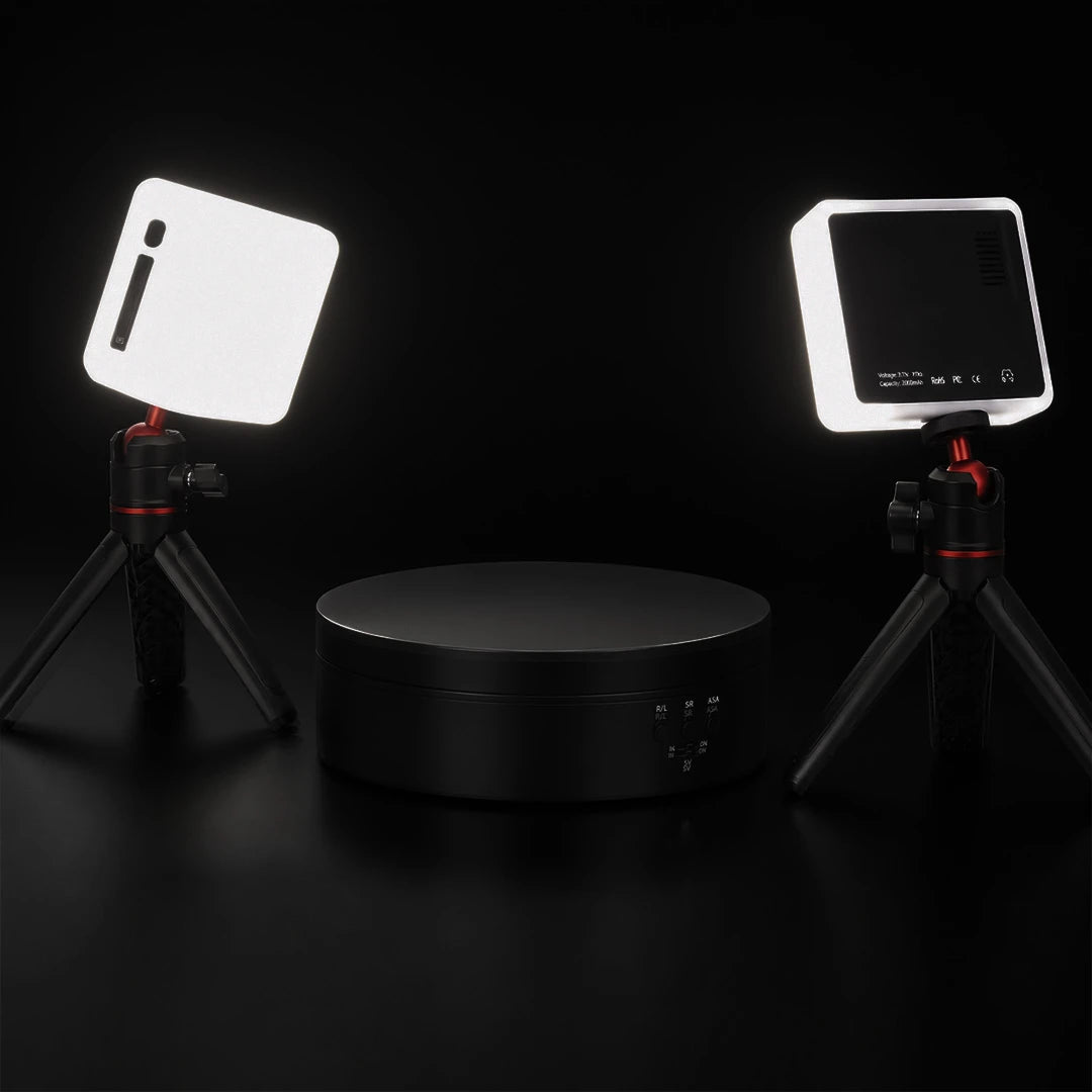 Two LED lights on tripods with a rotating base on a dark background.
