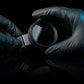 CPL filter for dental photography held with gloves close-up.