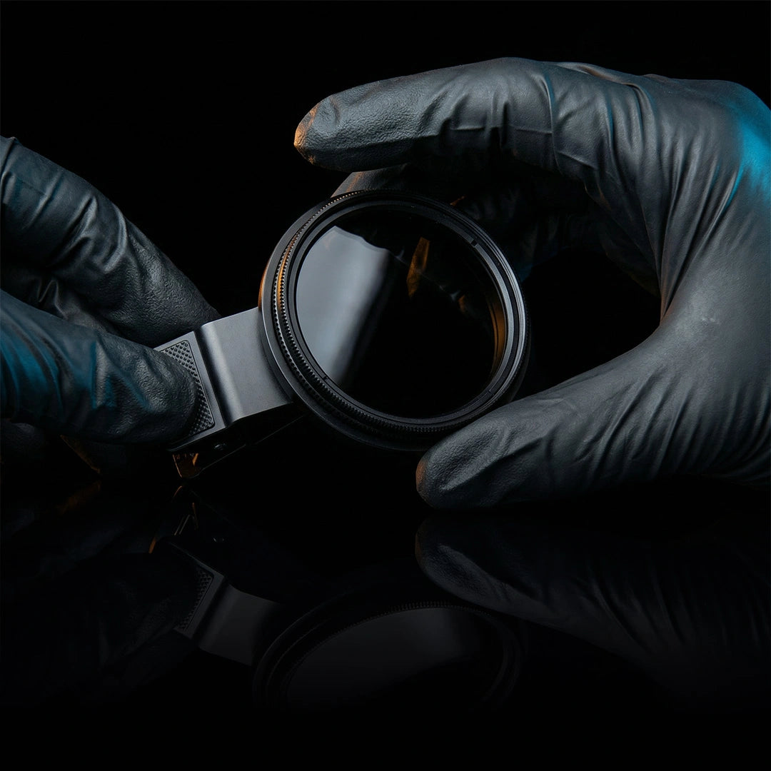 CPL filter for dental photography held with gloves close-up.