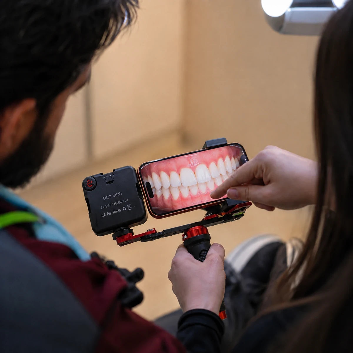 Dentist reviewing shade match on smartphone with Twin Light
