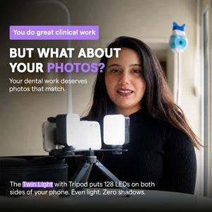 Dentist sitting with twin light and tripod setup in a dental clinic.